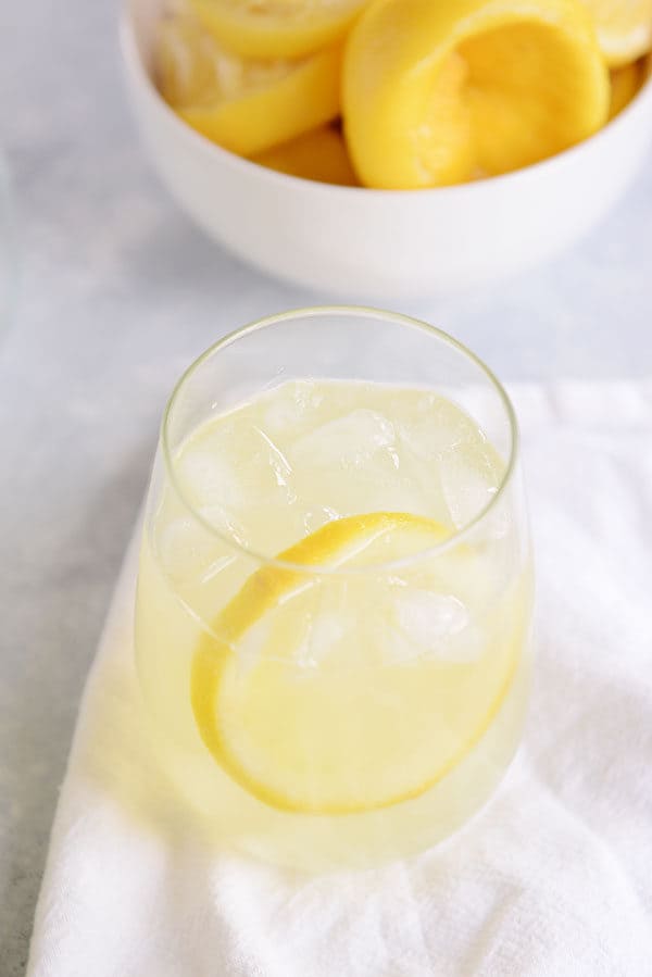 Un vaso pequeño de limonada y un tazón de jugo de limón.