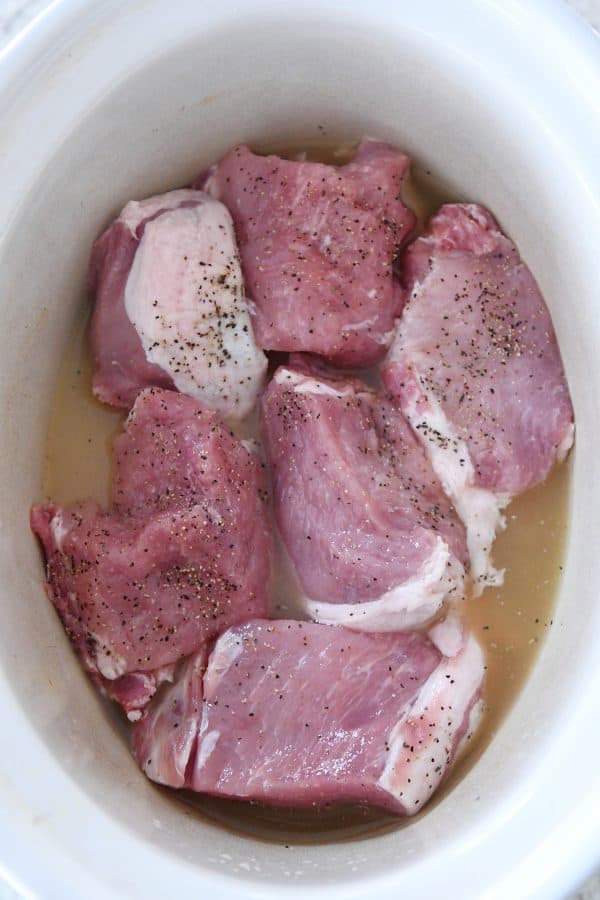 Asar cerdo crudo en una olla de cocción lenta.