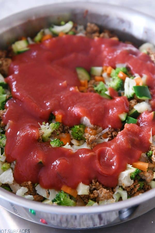 Agregue salsa de tomate al relleno de tacos.