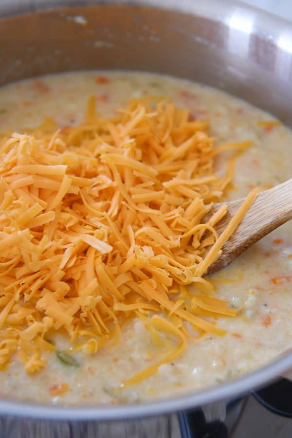 Agregue queso cheddar rallado a la sopa de brócoli