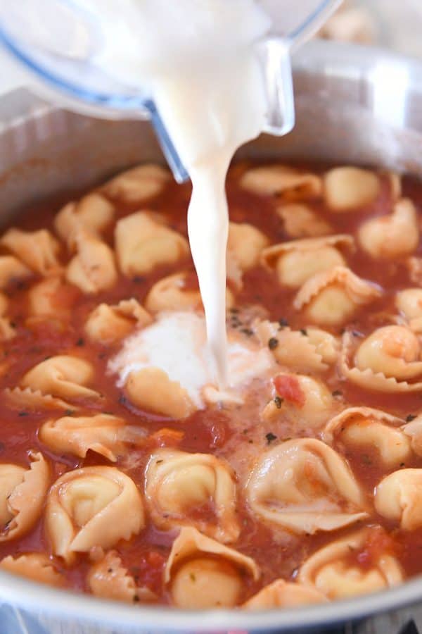Vierta la mezcla de leche + harina para hacer una sopa cremosa de Tortellini toscano rápida y fácil.