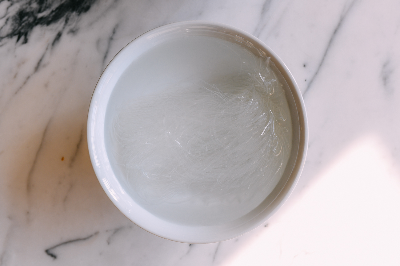 Fideos de frijol mungo empapado en agua en un recipiente blanco