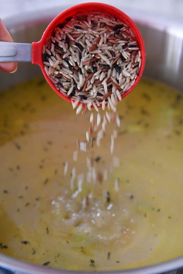 Agregue arroz integral y arroz salvaje a una olla de sopa cremosa de pavo.
