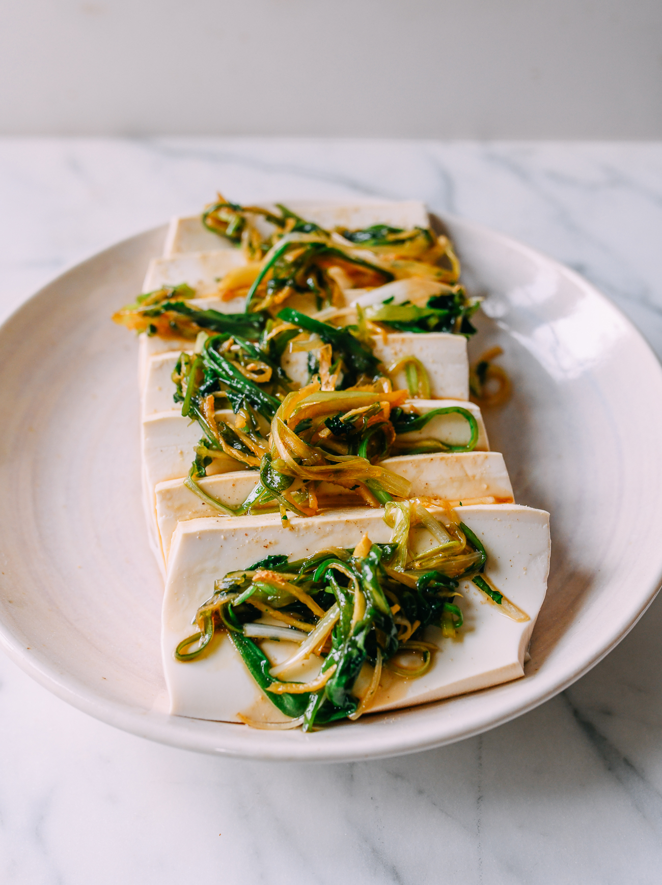 Unte cebollas verdes cocidas, cilantro y jengibre sobre el tofu