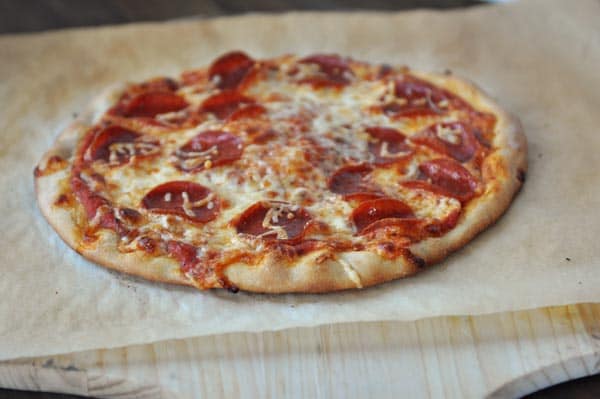 Pizza de pepperoni casera cocinada en un trozo de papel pergamino.