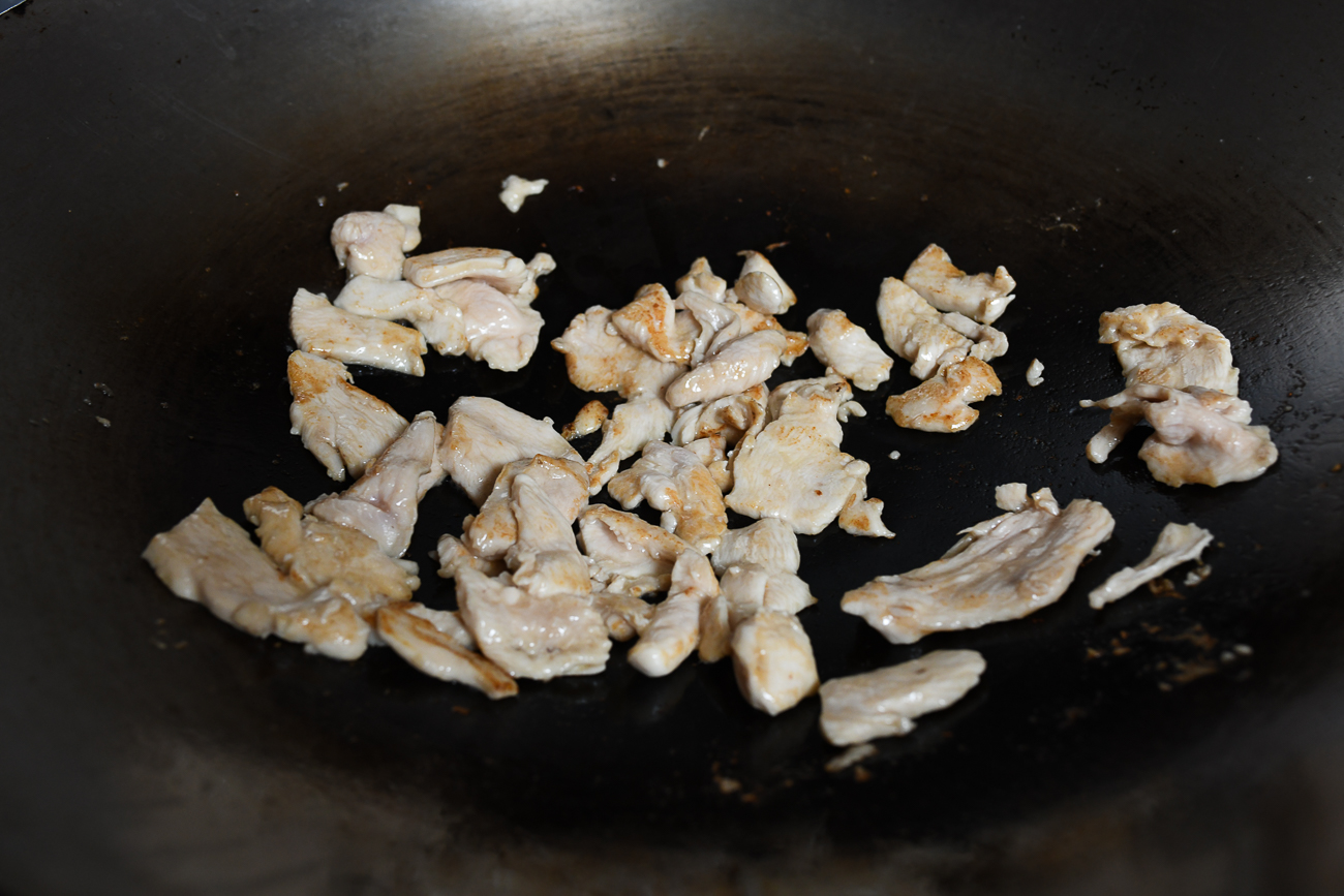 Saltear las rodajas de pollo en un wok