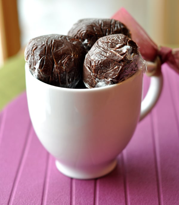 Saran envuelve bolas de trufa de chocolate caliente en vasos blancos