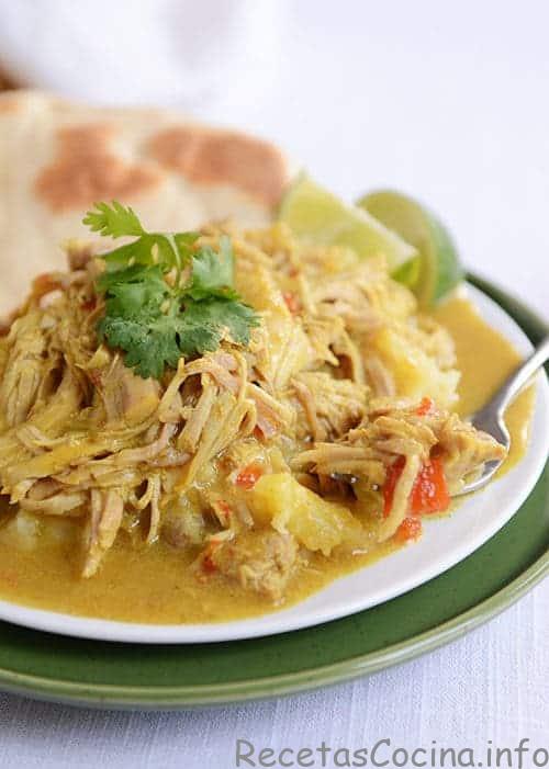 En el plato blanco se colocan trozos de cerdo al curry picante y un pan plano. 