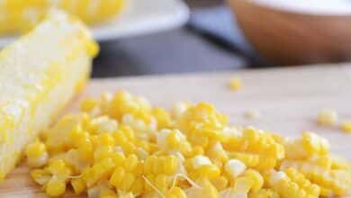 El maíz se corta de la mazorca en la tabla de cortar.