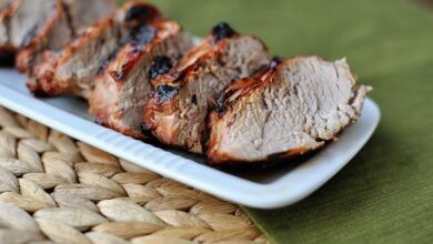 Solomillo de cerdo asado cortado en trozos gruesos y forrado en un plato rectangular blanco