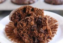 Muffins de calabacín de chocolate doble partidos por la mitad en el molde para muffins
