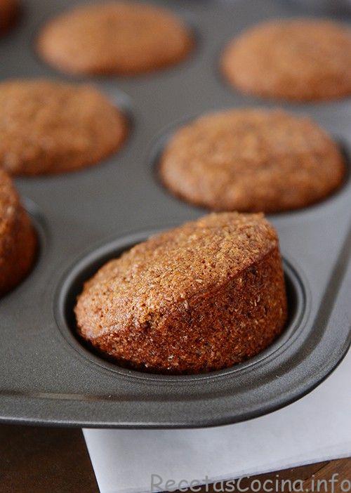 Muffins dorados en un molde para muffins, con los muffins delanteros ligeramente inclinados hacia arriba. 