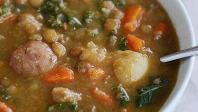 Un plato de sopa relleno de lentejas cocidas y verduras.