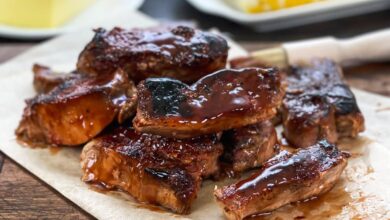 Country style pork ribs with BBQ sauce on a white platter.