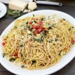 Fideos espaguetis con calabacín picado y tomates en un plato blanco.