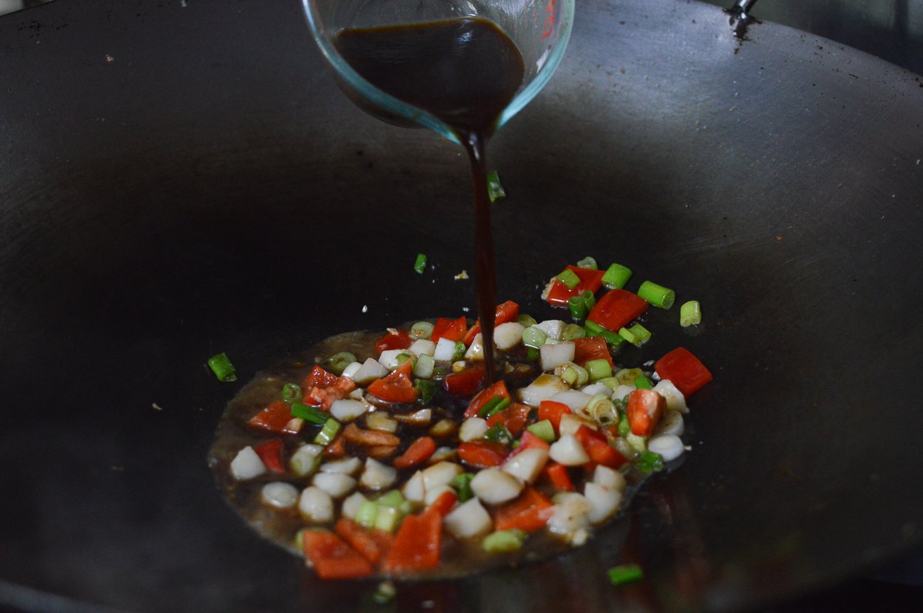 Verter los ingredientes de la salsa en el wok con verduras